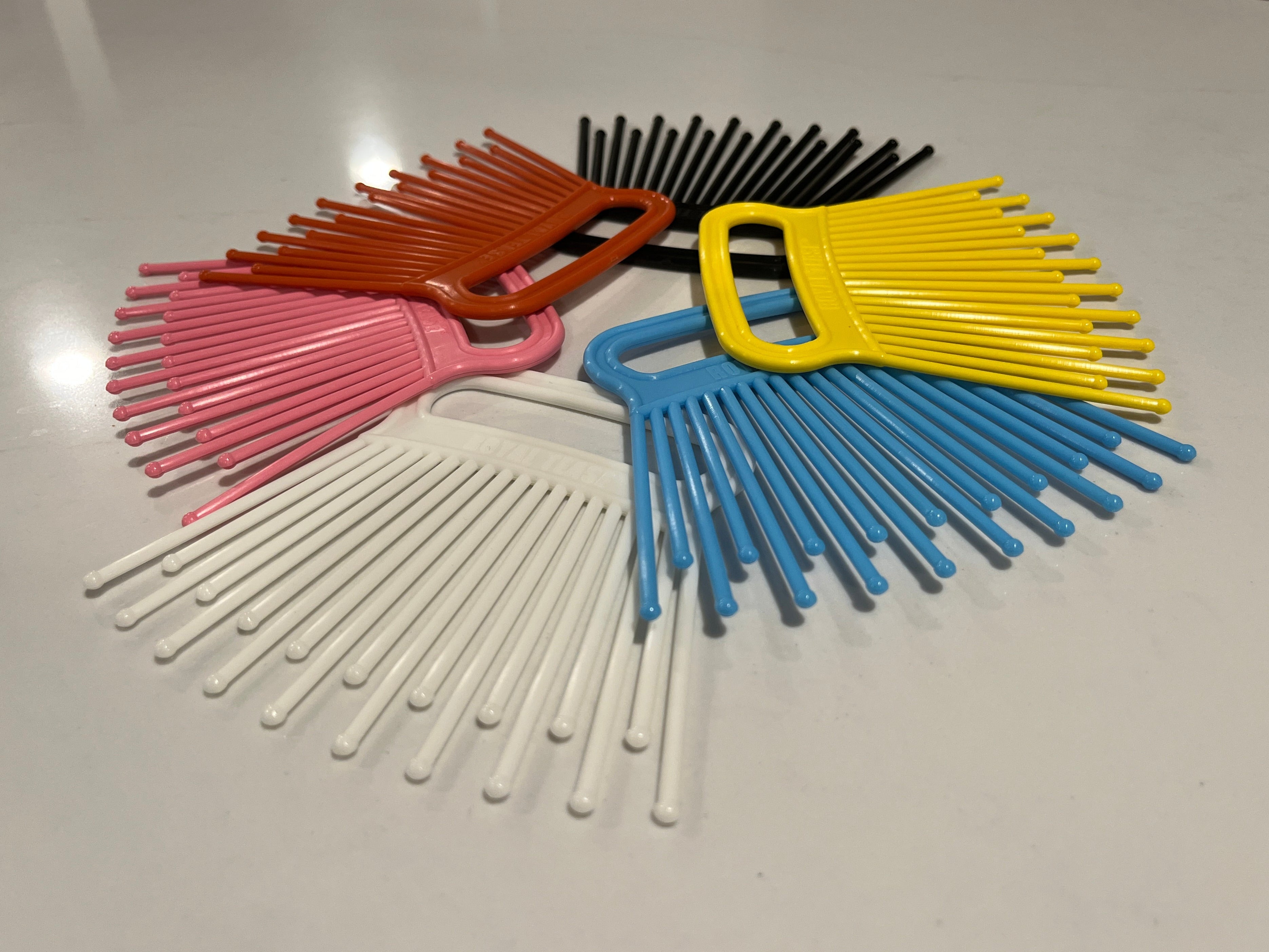 Colorful plastic combs on a white surface